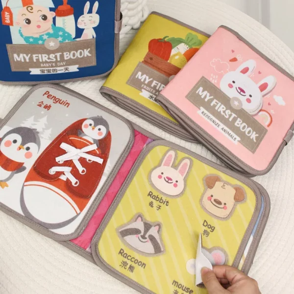 Livre d’activité Montessori en tissu pour bébés. Stimule la motricité fine et l’éveil sensoriel avec des objets à manipuler et des illustrations à placer. Doux, lavable et certifié CE.